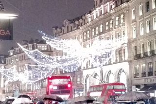 London zu Weihnachten: Doppeldeckerbusse, Weihnachtsbeleuchtung und Menschen mit Regenschirmen in der Regent Street